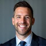 Man in suit, smiling - Lucas Brown
